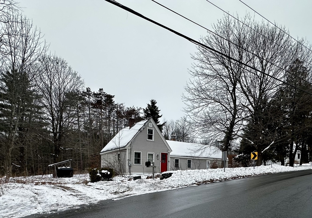 a front view of a house with a yard and tree s