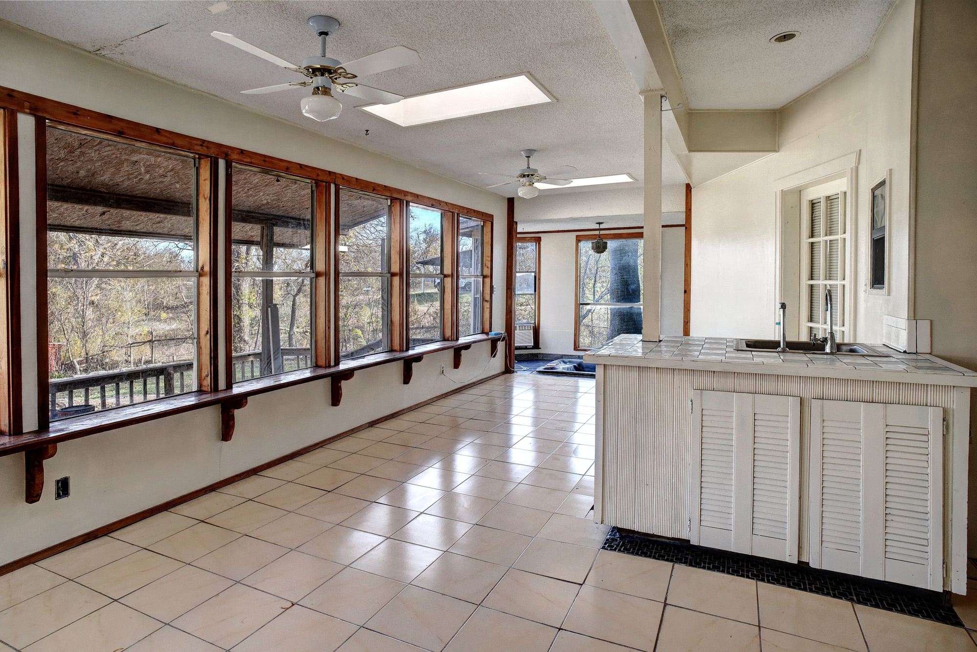113 My Road Bastrop, TX 78602 - Photo 18 of 35 Kitchen with ceiling fan, tile counters, a skylight, a textured ceiling, and light tile patterned flooring