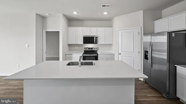 a kitchen with stainless steel appliances a stove a sink a microwave and cabinets