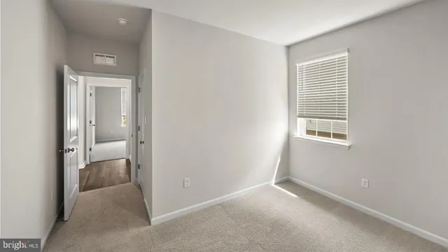 an empty room and a bathroom with a sink