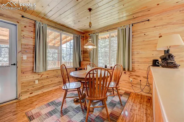 a dining hall with stainless steel appliances granite countertop a table chairs and view of living room