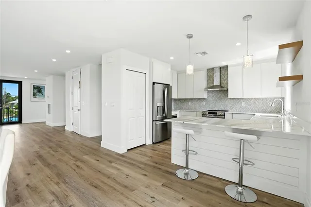 a kitchen with a refrigerator a sink and white cabinets