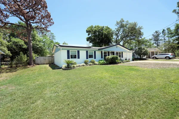 a front view of a house with a yard and trees