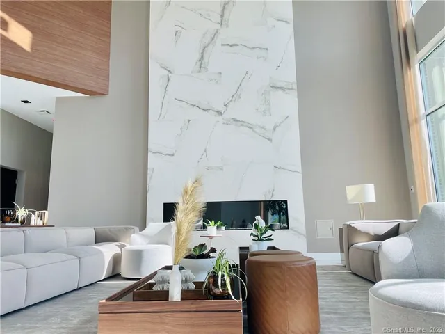 a living room with furniture a fireplace and a large window