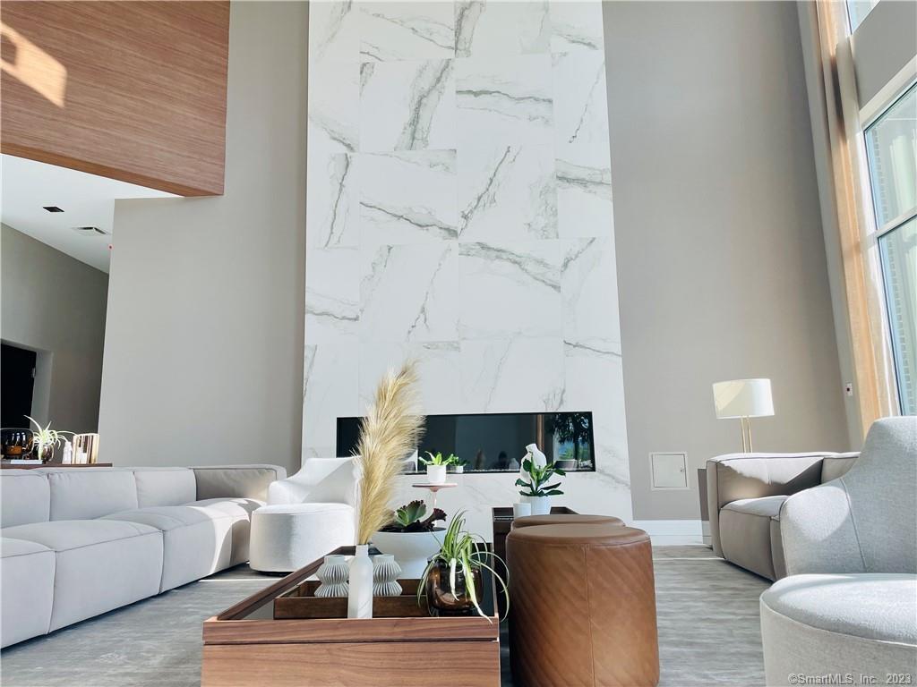 a living room with furniture a fireplace and a large window