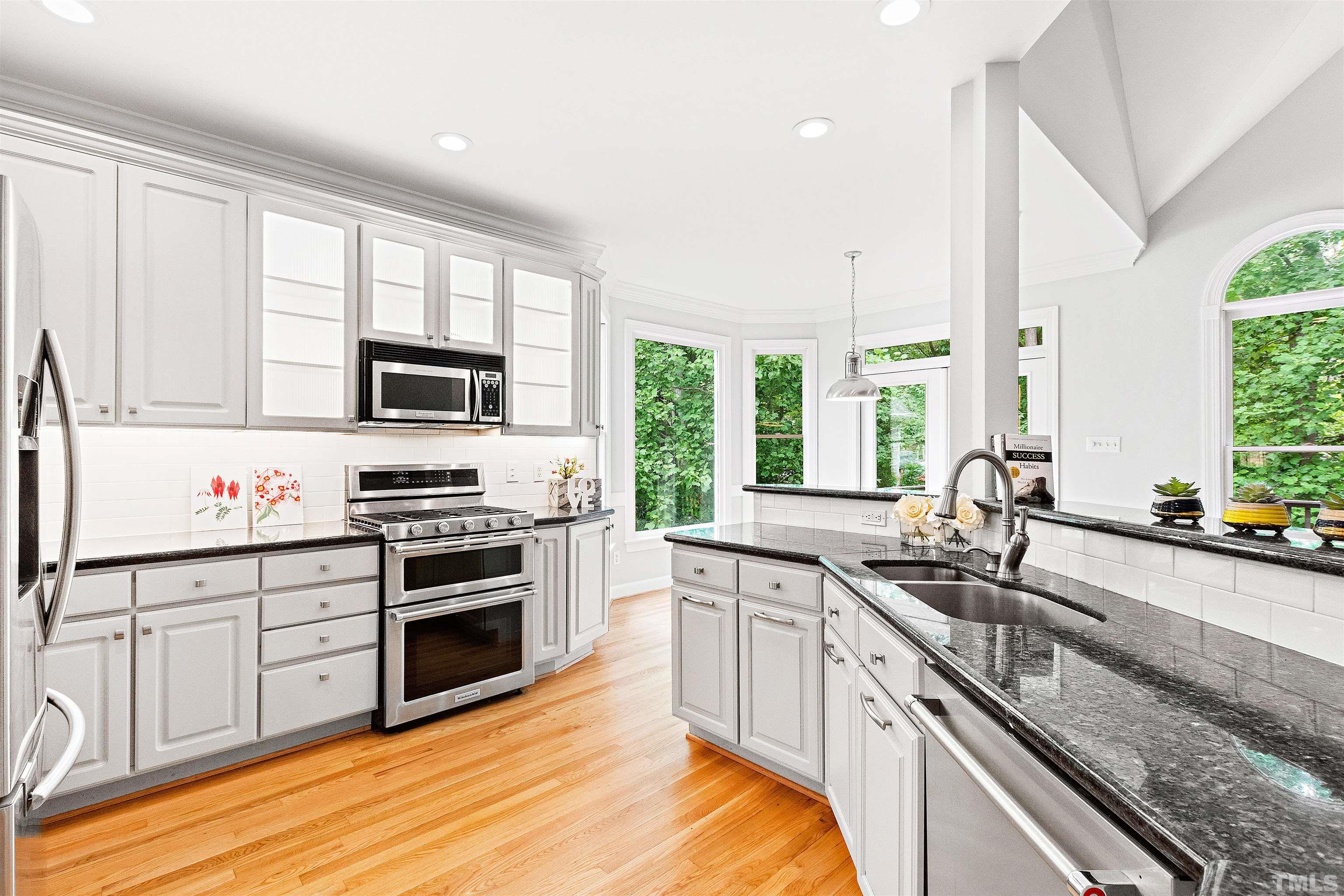 1912 Amity Hill Court Raleigh, NC 27612 - Photo 9 of 36 a kitchen with stainless steel appliances a sink cabinets and a large window