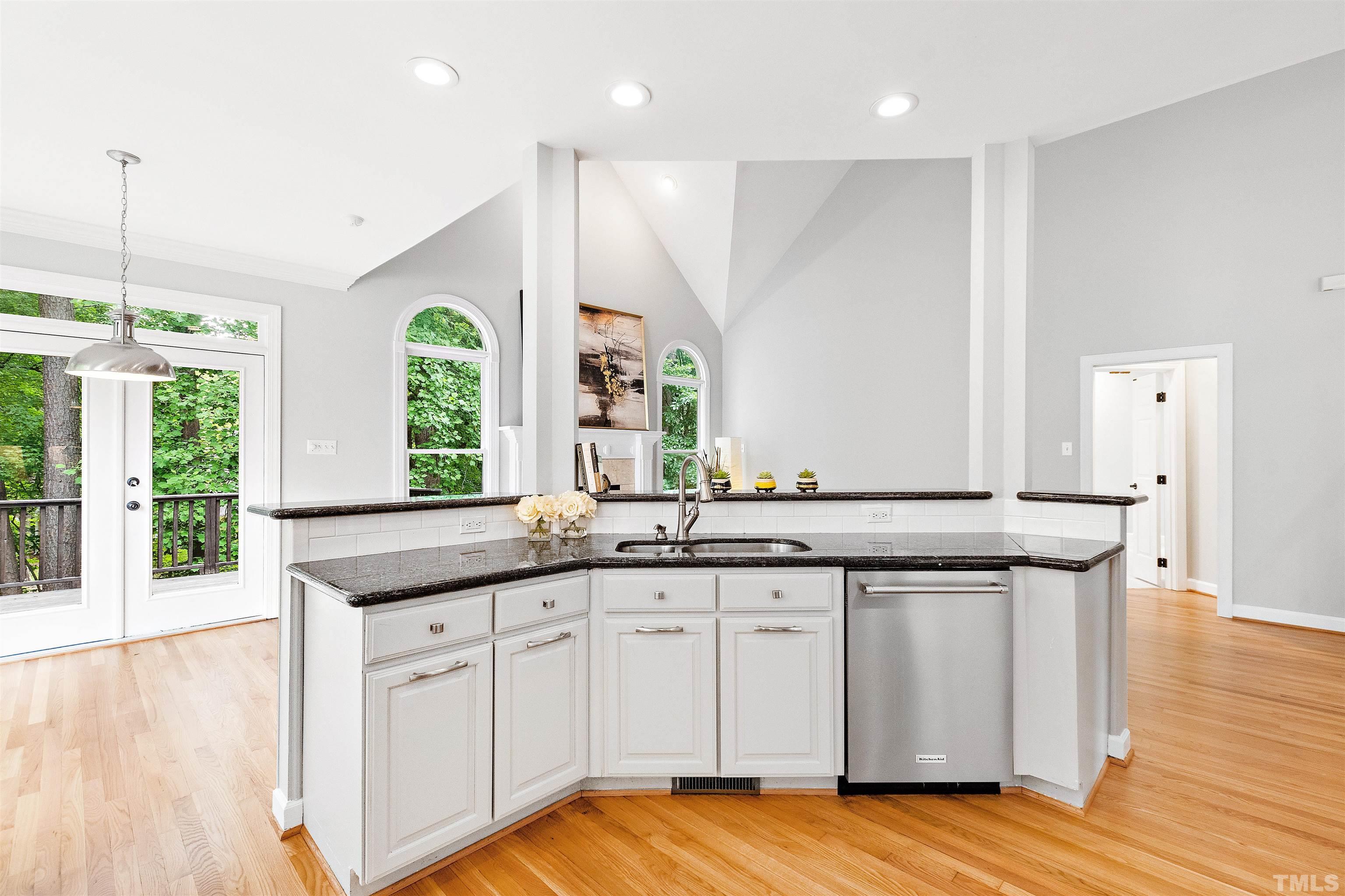1912 Amity Hill Court Raleigh, NC 27612 - Photo 10 of 36 a kitchen with granite countertop a sink and white cabinets with wooden floor