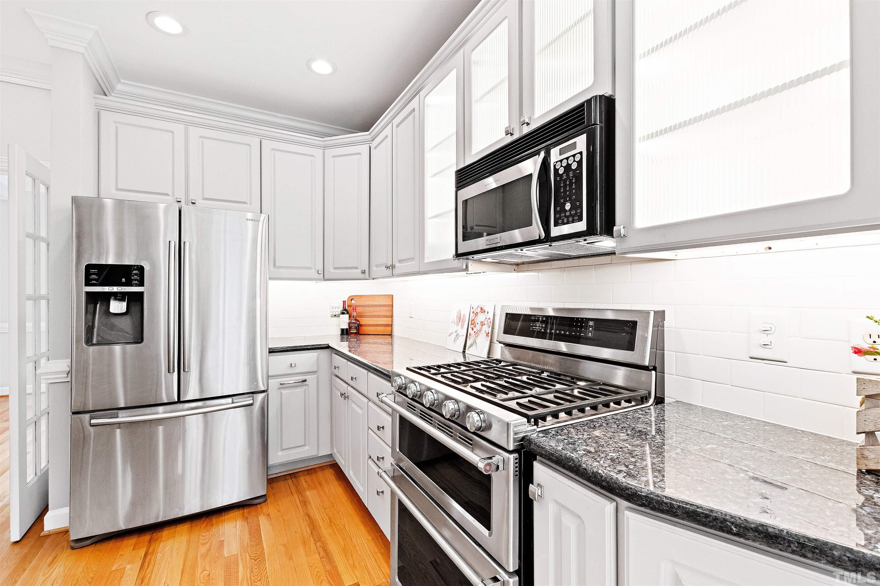 1912 Amity Hill Court Raleigh, NC 27612 - Photo 11 of 36 a kitchen with stainless steel appliances white cabinets and a stove top oven