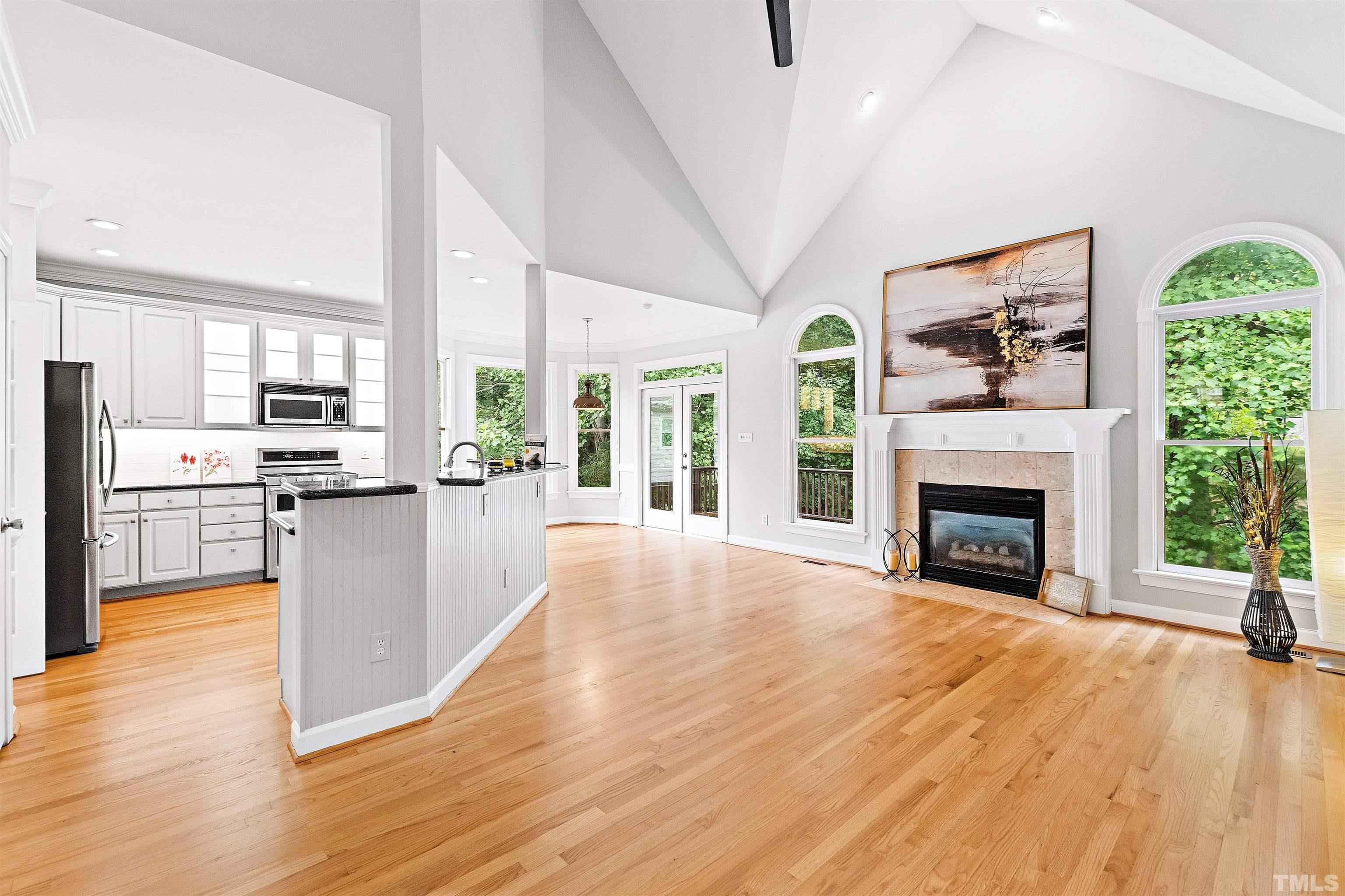 1912 Amity Hill Court Raleigh, NC 27612 - Photo 35 of 36 a view of an empty room and kitchen with fireplace wooden floor and windows