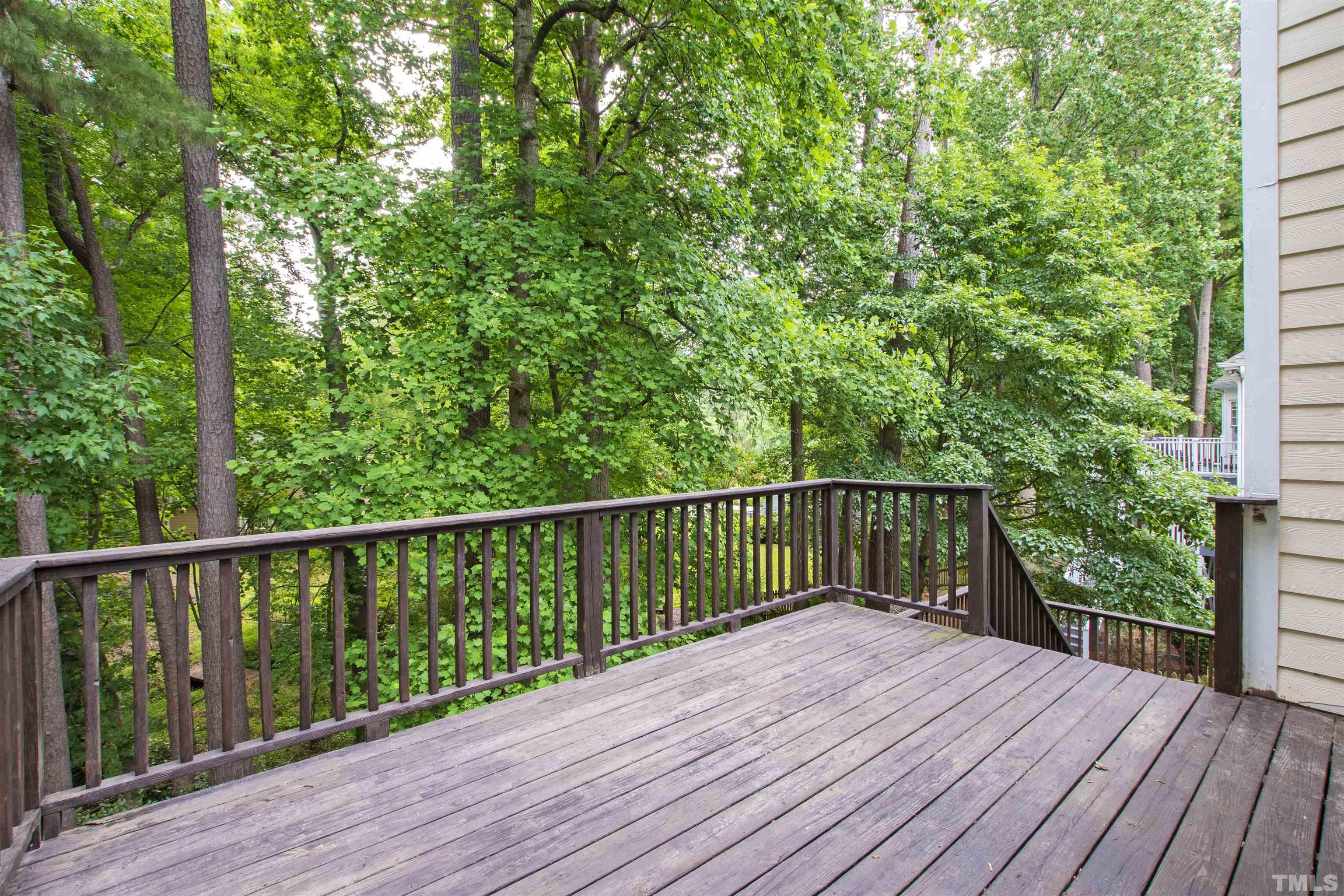 1912 Amity Hill Court Raleigh, NC 27612 - Photo 32 of 36 a balcony with wooden floor and trees in the back