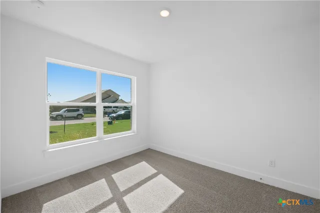 a view of an empty room with a window and closet