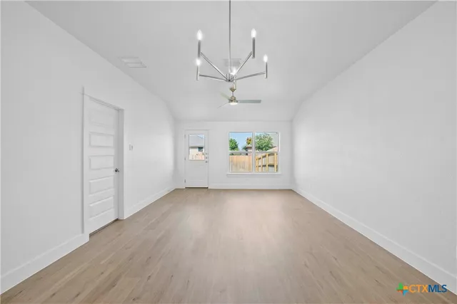 an empty room with a window and a ceiling fan