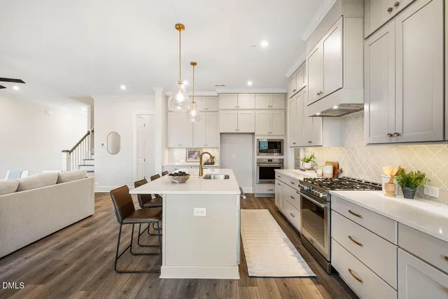 a kitchen with a sink a stove and chairs