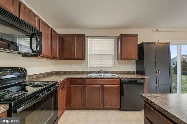 a kitchen with stainless steel appliances granite countertop a stove a sink dishwasher and a refrigerator