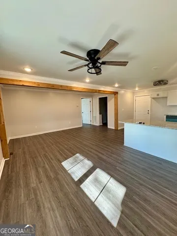 a view of a room with wooden floor and a ceiling fan