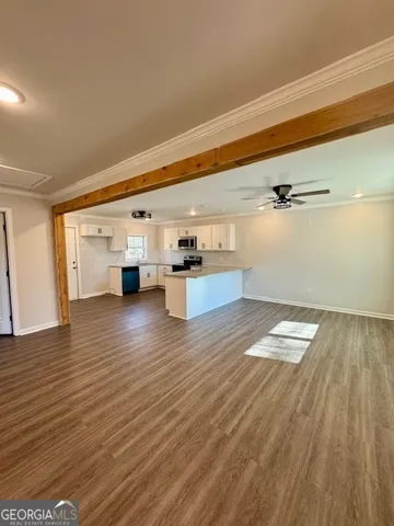 a view of empty room with wooden floor and window