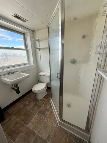 a bathroom with a granite countertop sink toilet and shower