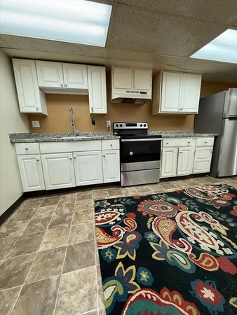 a kitchen with stainless steel appliances granite countertop a sink stove and cabinets