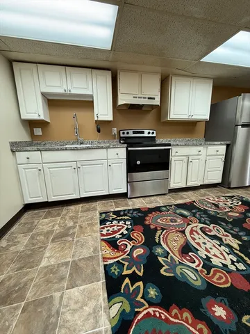 a kitchen with stainless steel appliances granite countertop a sink stove and cabinets