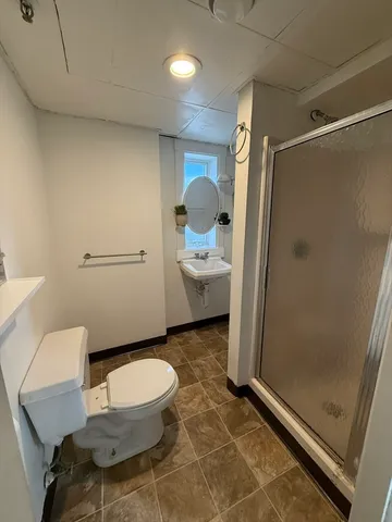 a bathroom with a toilet and a shower