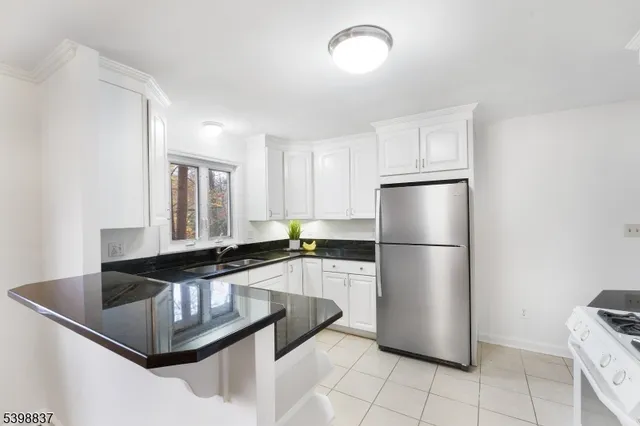 a kitchen with granite countertop a refrigerator stove and microwave