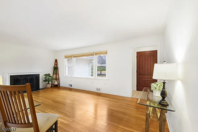 a view of an empty room with furniture and a window