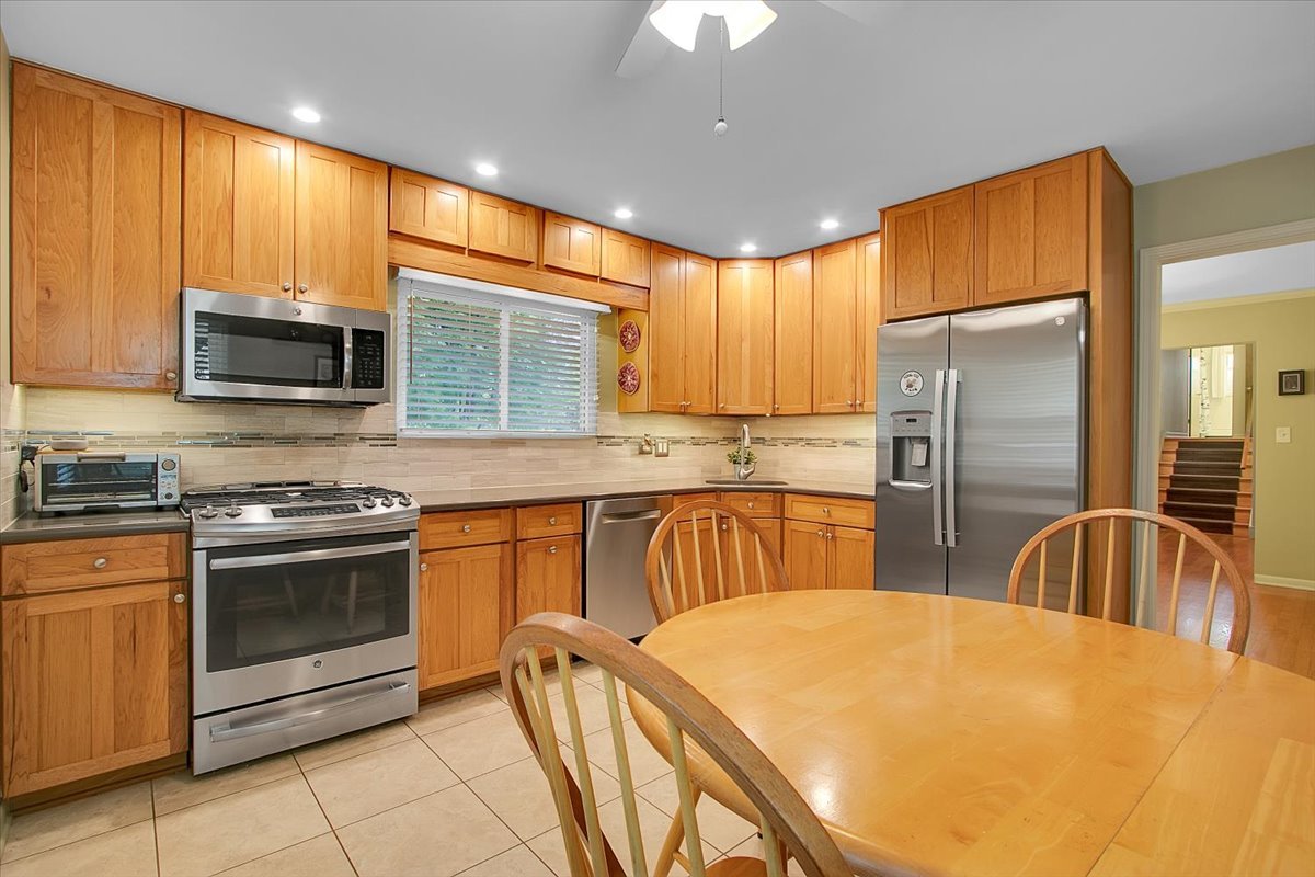 443 Lombard Road Itasca, IL 60143 - Photo 10 of 43 a kitchen with stainless steel appliances granite countertop a sink a stove a refrigerator cabinets and a dining table