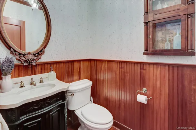 a bathroom with a sink a toilet and mirror