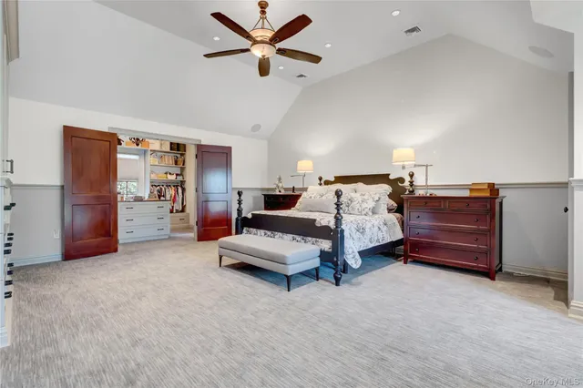 a spacious bedroom with a bed and ceiling fan