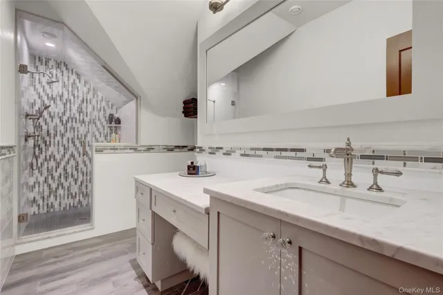 a spacious bedroom with a bed and a flat tv screen on the dresser