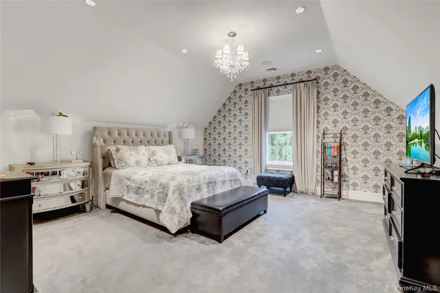 a spacious bedroom with a bed and a chandelier