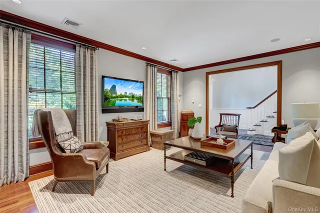 a living room with furniture a flat screen tv and a floor to ceiling window