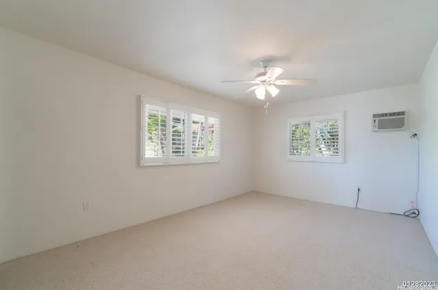 an empty room with a window and a ceiling fan