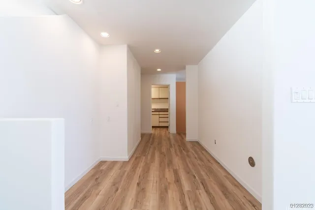 a view of a room with wooden floor and a window