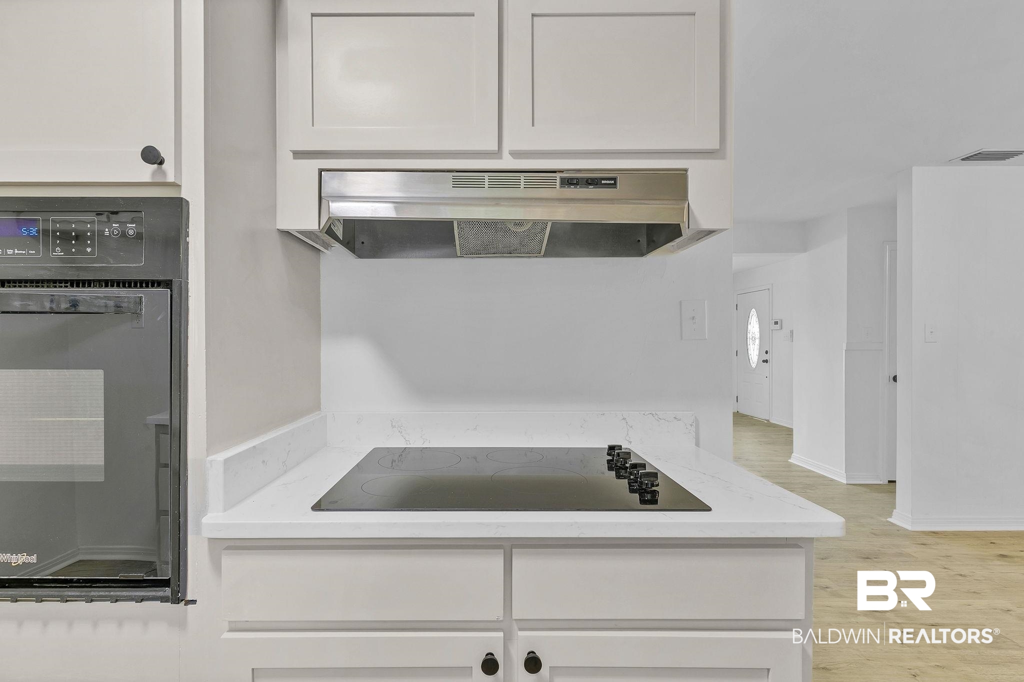 203 Anderson Road Saraland, AL 36571 - Photo 18 of 48 Kitchen featuring visible vents, white cabinets, under cabinet range hood, light wood finished floors, and black appliances