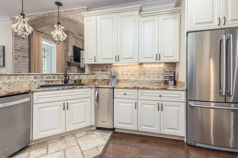 a kitchen with stainless steel appliances granite countertop a sink a stove and cabinets