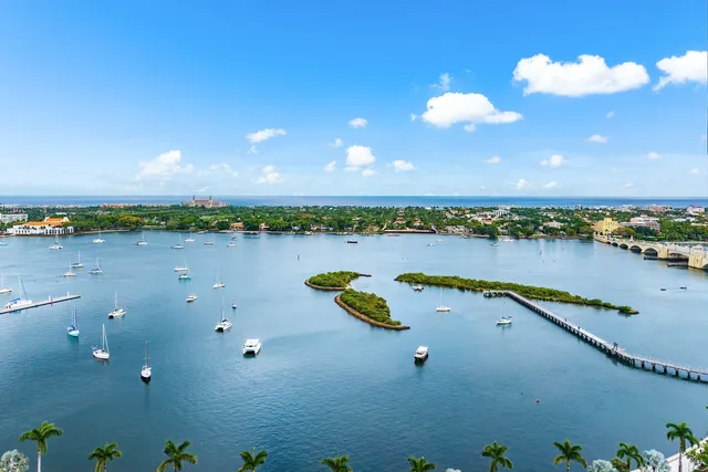 a view of a lake with outdoor space and lots of trees in the background
