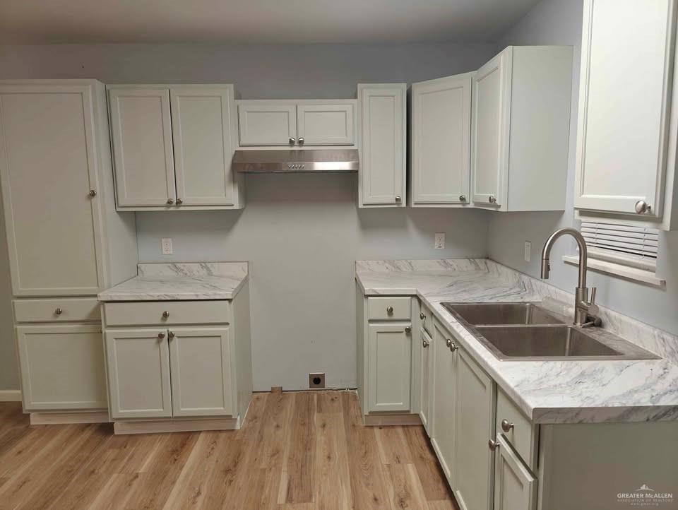 2736 Naples Street Weslaco, TX 78596 - Photo 4 of 14 a kitchen with white cabinets sink and stove