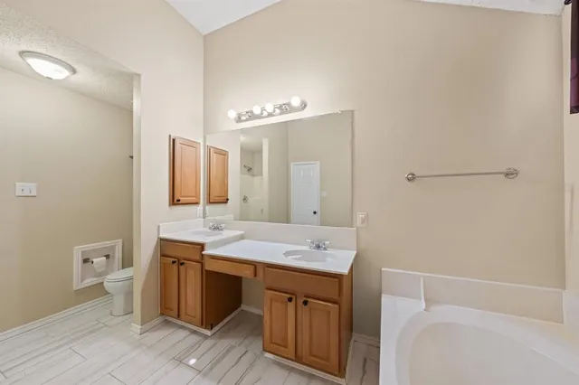 a spacious bathroom with a double vanity sink a mirror and a bathtub