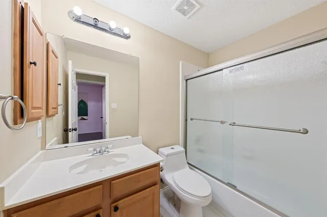 a bathroom with a sink a toilet a mirror and shower