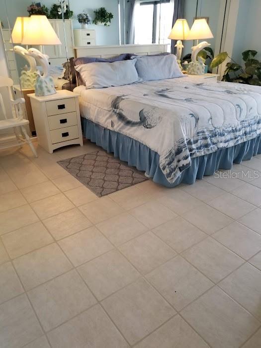 13650 Gulf Boulevard, Unit 304 Madeira Beach, FL 33708 - Photo 40 of 63 a bedroom with a bed and a chandelier