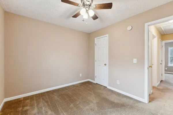 a view of an empty room and chandelier fan