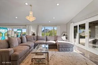 a living room with furniture a chandelier and a large window