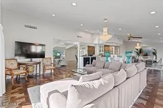 a living room with furniture kitchen view and a flat screen tv