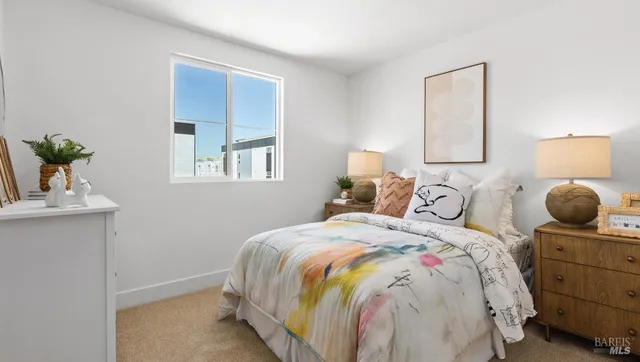 a bedroom with a bed and potted plant on the dresser