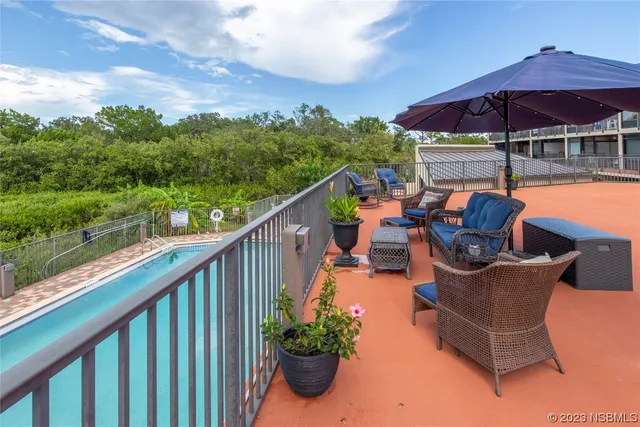 a balcony with furniture and an umbrella