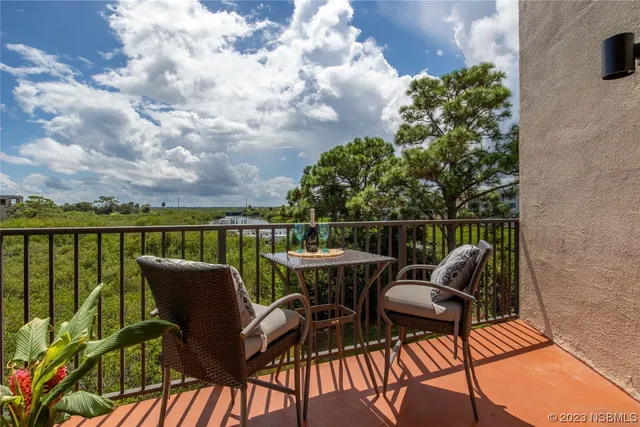 a view of a balcony with two chairs and a potted plant