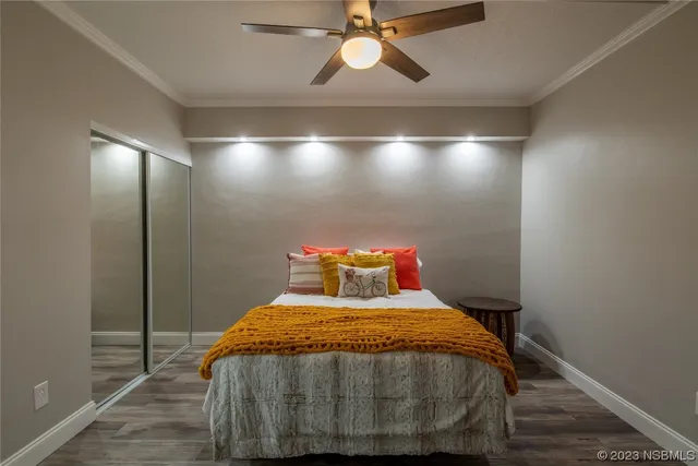 a bed sitting in a bedroom next to a window and a chandelier