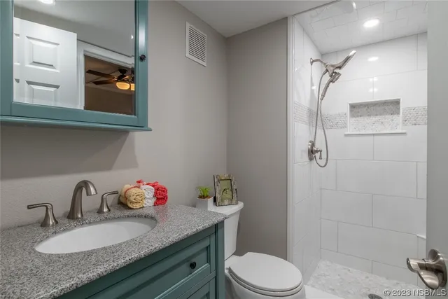 a bathroom with a granite countertop sink toilet and shower