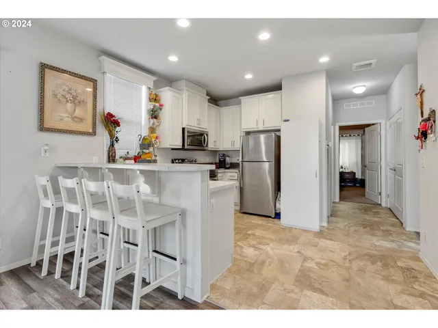 a kitchen with stainless steel appliances kitchen island granite countertop a refrigerator and microwave